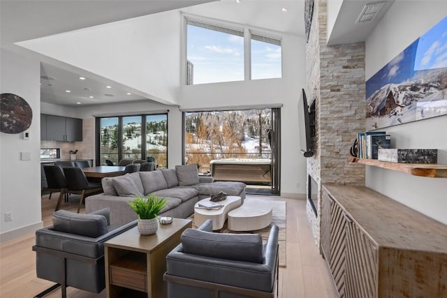 living room featuring a high ceiling and light hardwood / wood-style flooring