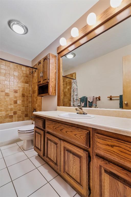 full bathroom with shower / tub combo with curtain, vanity, and toilet