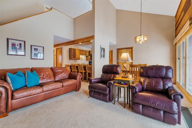 living room with light carpet, high vaulted ceiling, and a chandelier