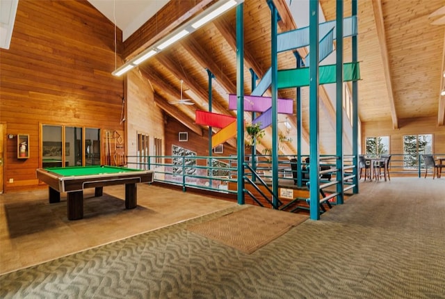 rec room featuring carpet flooring, beam ceiling, high vaulted ceiling, and wood walls