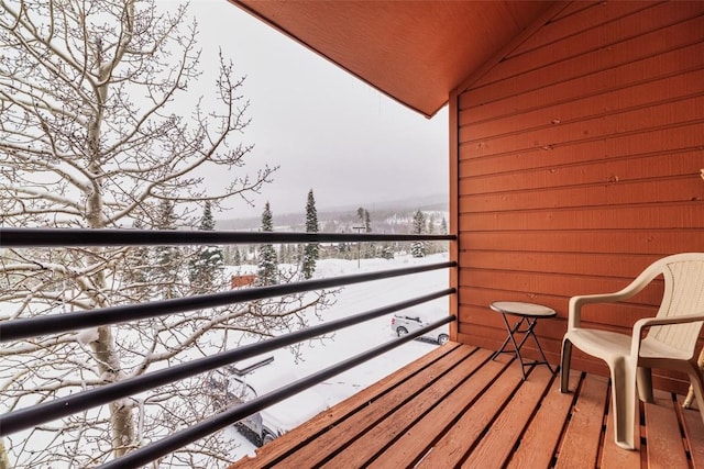 view of snow covered back of property