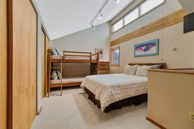 carpeted bedroom featuring a towering ceiling and rail lighting