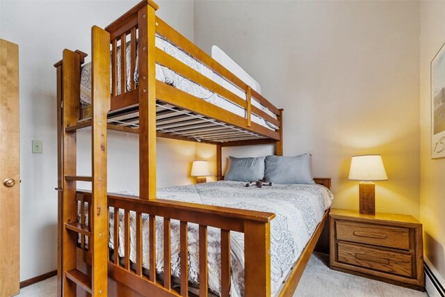 bedroom featuring light colored carpet and baseboard heating