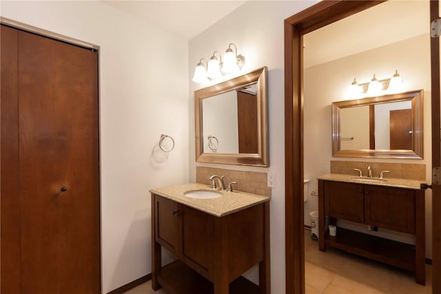 bathroom with tile patterned flooring, vanity, and tasteful backsplash