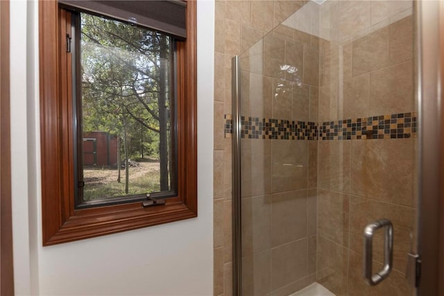 bathroom with a shower with door