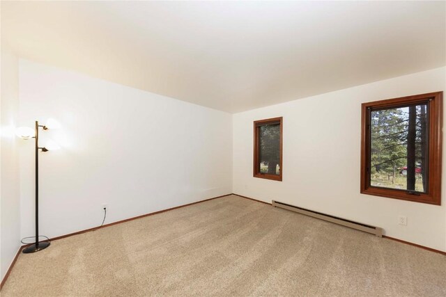 carpeted empty room featuring baseboard heating