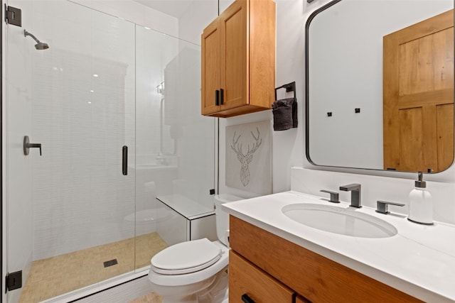 bathroom with vanity, toilet, and a shower with door