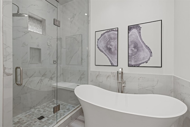 bathroom featuring plus walk in shower and tile walls