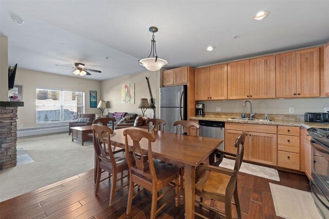 dining area featuring a fireplace, dark hardwood / wood-style flooring, ceiling fan, and sink