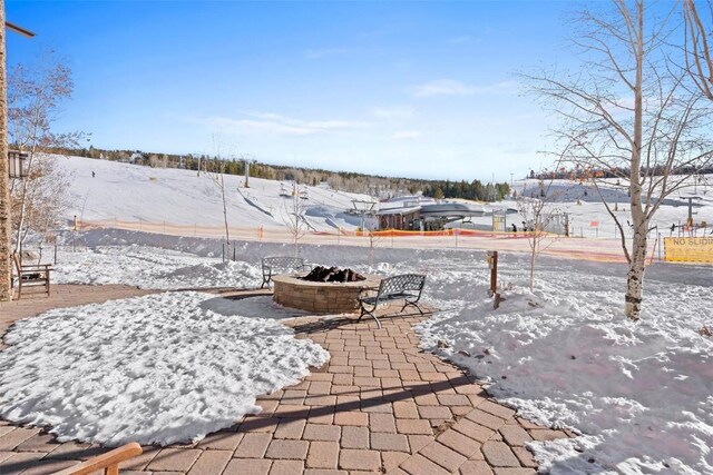 snow covered patio featuring a fire pit