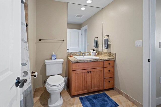 bathroom with tile patterned flooring, vanity, and toilet