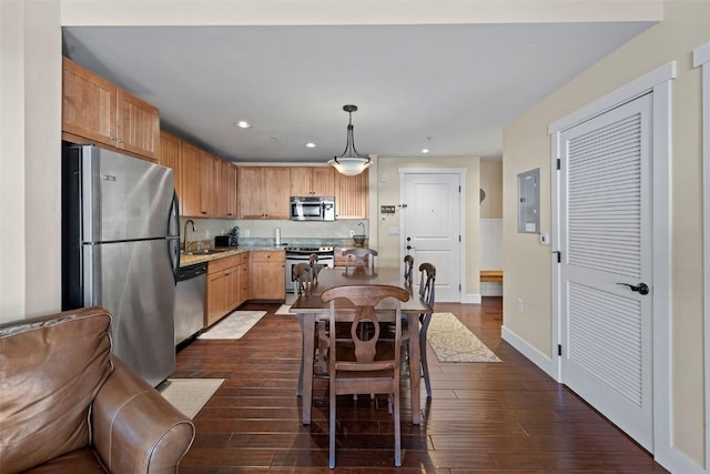 kitchen featuring pendant lighting, sink, dark wood-type flooring, and appliances with stainless steel finishes