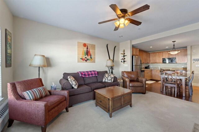 living room with ceiling fan and light colored carpet