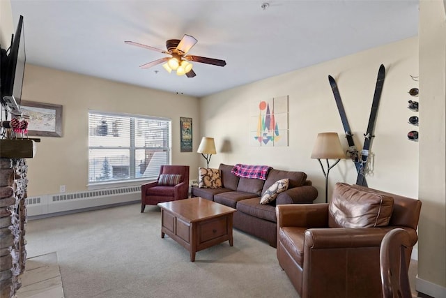 carpeted living room featuring radiator, ceiling fan, and a fireplace