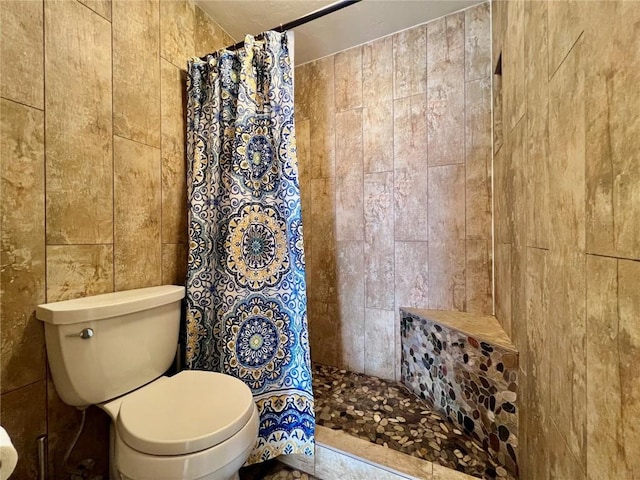 bathroom with a shower with shower curtain and toilet