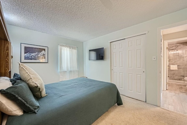 carpeted bedroom featuring a textured ceiling, a closet, and connected bathroom