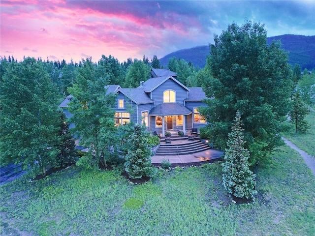 view of front of property featuring a mountain view and a patio