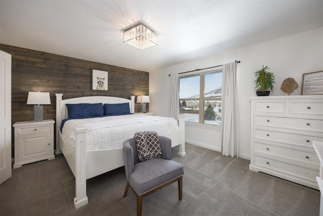 bedroom featuring dark carpet and wood walls