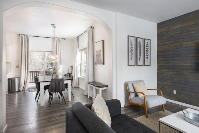 dining space with dark hardwood / wood-style floors and wood walls