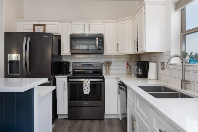 kitchen featuring stainless steel appliances, sink, white cabinets, and decorative backsplash