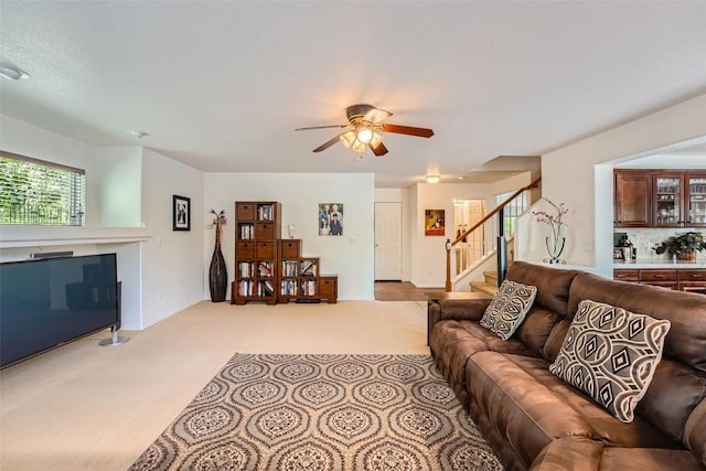 carpeted living room with ceiling fan