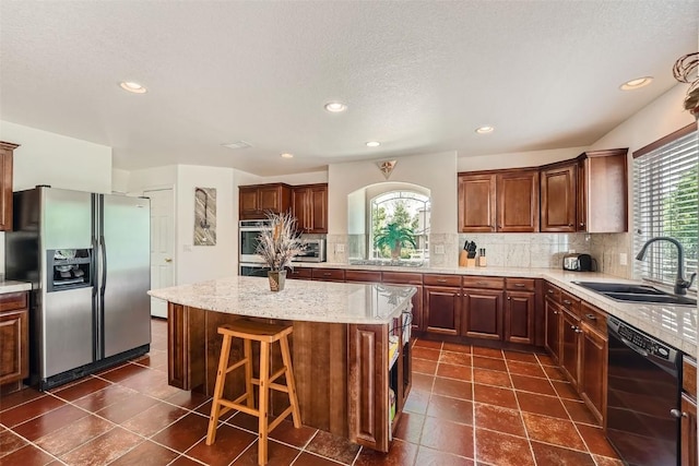 kitchen featuring stainless steel fridge, black dishwasher, a kitchen island, and a healthy amount of sunlight