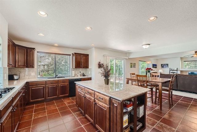 kitchen featuring a center island, sink, black dishwasher, and tasteful backsplash