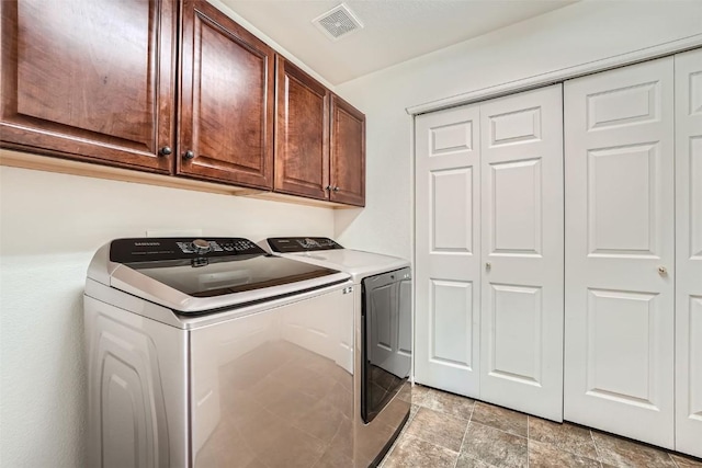 washroom featuring cabinets and washer and dryer