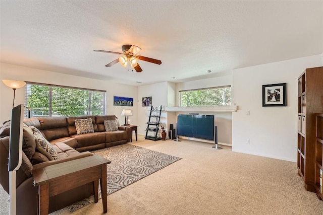 living room with ceiling fan, light colored carpet, and a textured ceiling