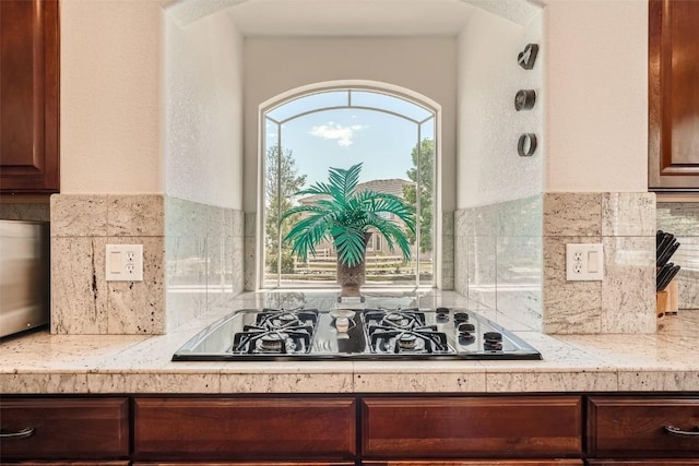 kitchen featuring black gas stovetop and backsplash