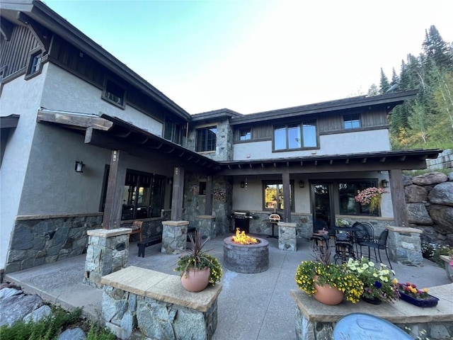 back of house featuring a fire pit and a patio