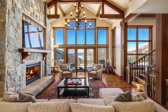 living room featuring a mountain view, hardwood / wood-style flooring, a notable chandelier, and a stone fireplace