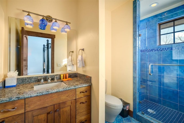 bathroom with toilet, a shower with shower door, and vanity