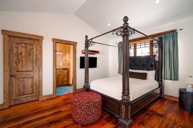 bedroom with dark hardwood / wood-style floors, connected bathroom, and vaulted ceiling