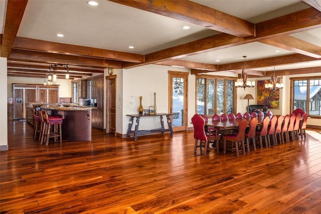 dining space with dark hardwood / wood-style floors, beamed ceiling, a notable chandelier, and a healthy amount of sunlight