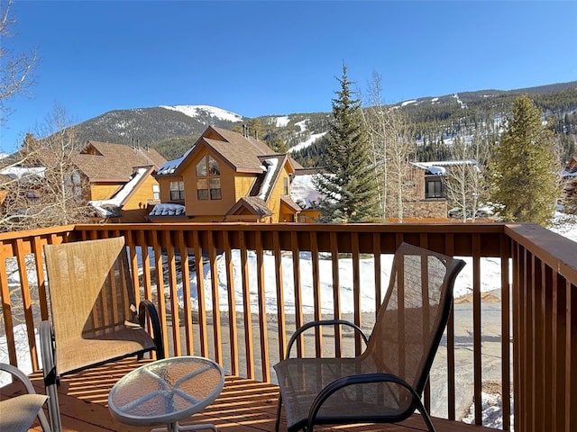 snow covered back of property with a mountain view