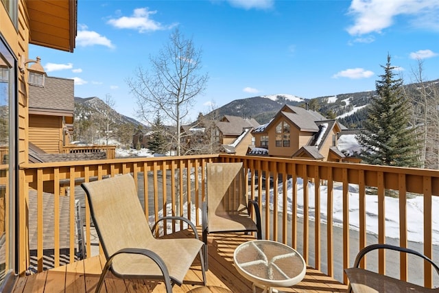 snow covered deck with a mountain view