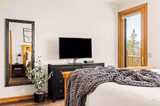 bedroom featuring multiple windows and wood finished floors