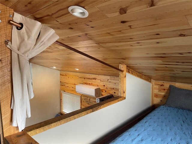 bedroom featuring a wall unit AC, wood ceiling, and wooden walls