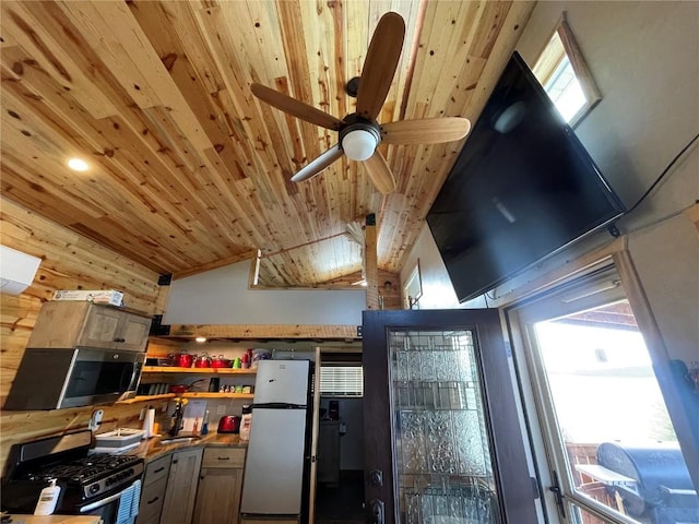 kitchen featuring stainless steel appliances, vaulted ceiling, ceiling fan, a healthy amount of sunlight, and wooden ceiling