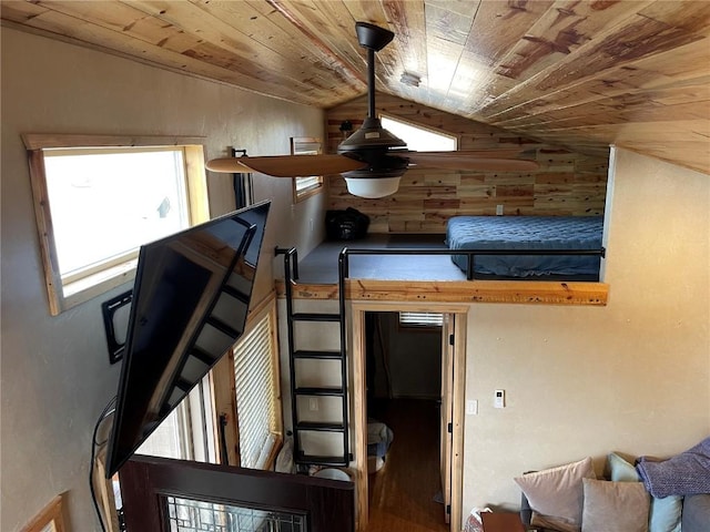 stairway with wooden walls, wood ceiling, and lofted ceiling