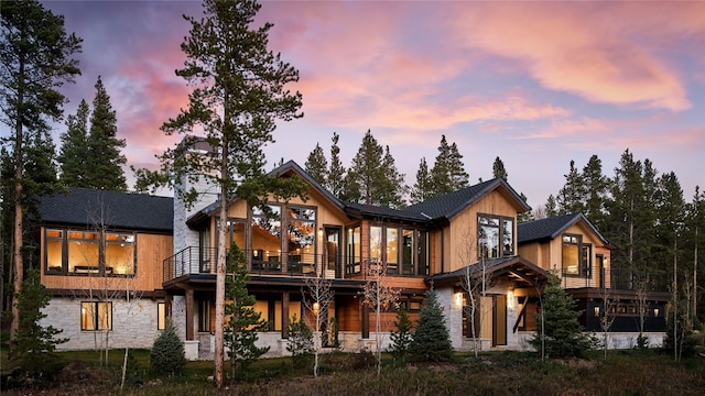 back house at dusk with a balcony