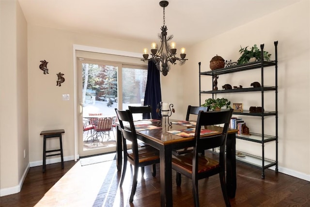 dining space with dark hardwood / wood-style floors and a chandelier