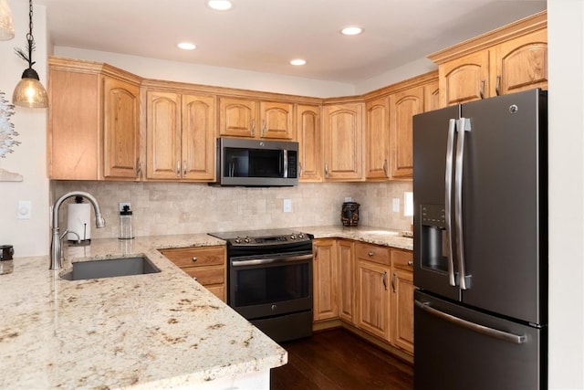 kitchen with stainless steel appliances, hanging light fixtures, sink, and light stone counters