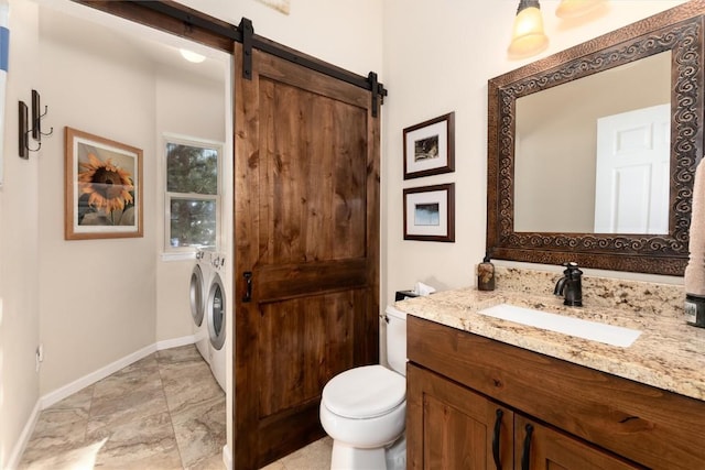 bathroom with vanity, independent washer and dryer, and toilet