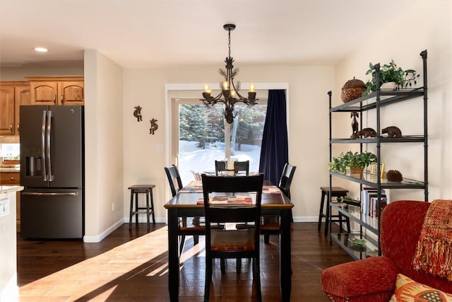 dining area with dark hardwood / wood-style flooring and a chandelier