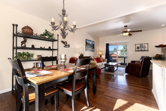 dining space with dark hardwood / wood-style flooring and ceiling fan with notable chandelier