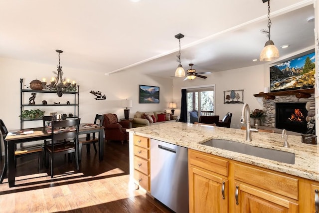 kitchen featuring sink, light stone countertops, dark hardwood / wood-style floors, and dishwasher