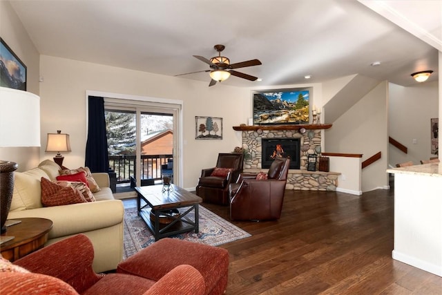 living room with ceiling fan, a fireplace, and dark hardwood / wood-style flooring