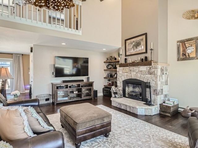 living room featuring a fireplace, wood-type flooring, and a high ceiling